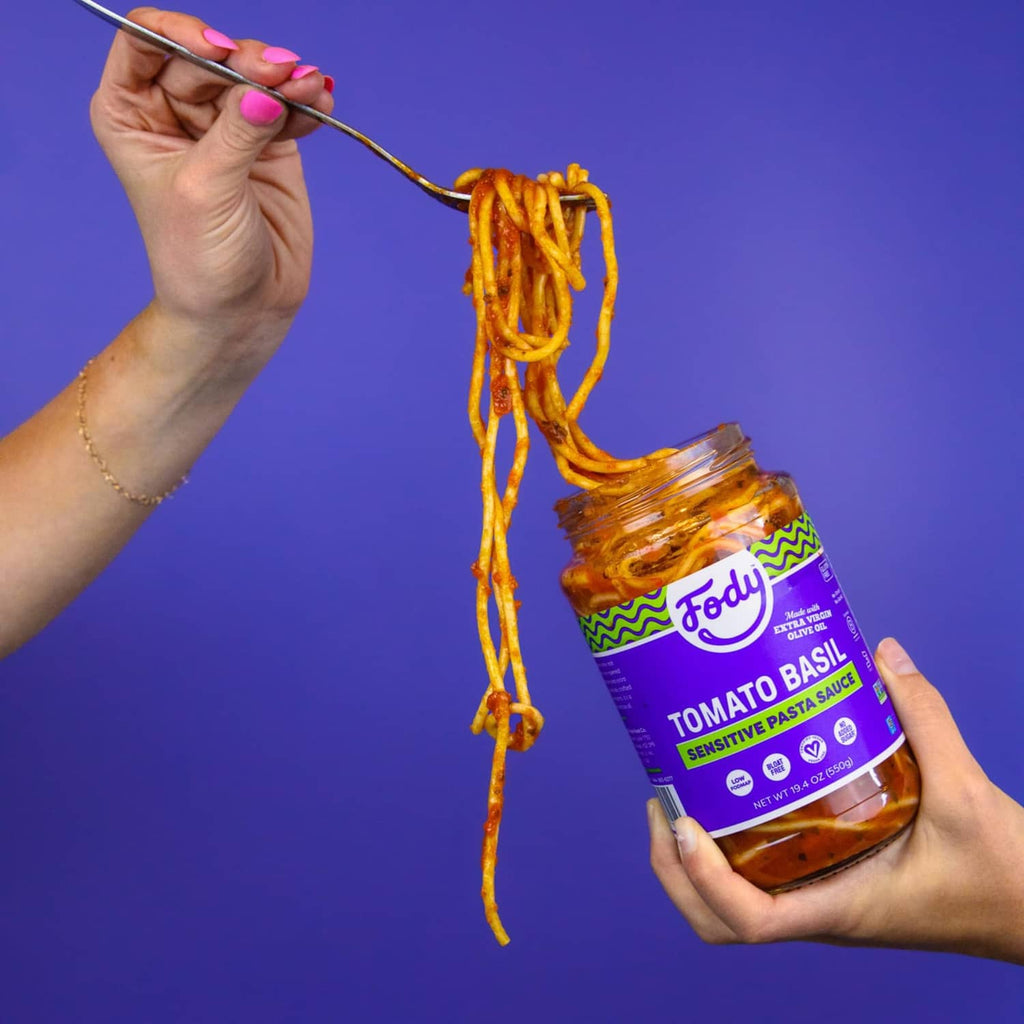 Fody tomato basil pasta sauce bottle held while lifting spaghetti noodles