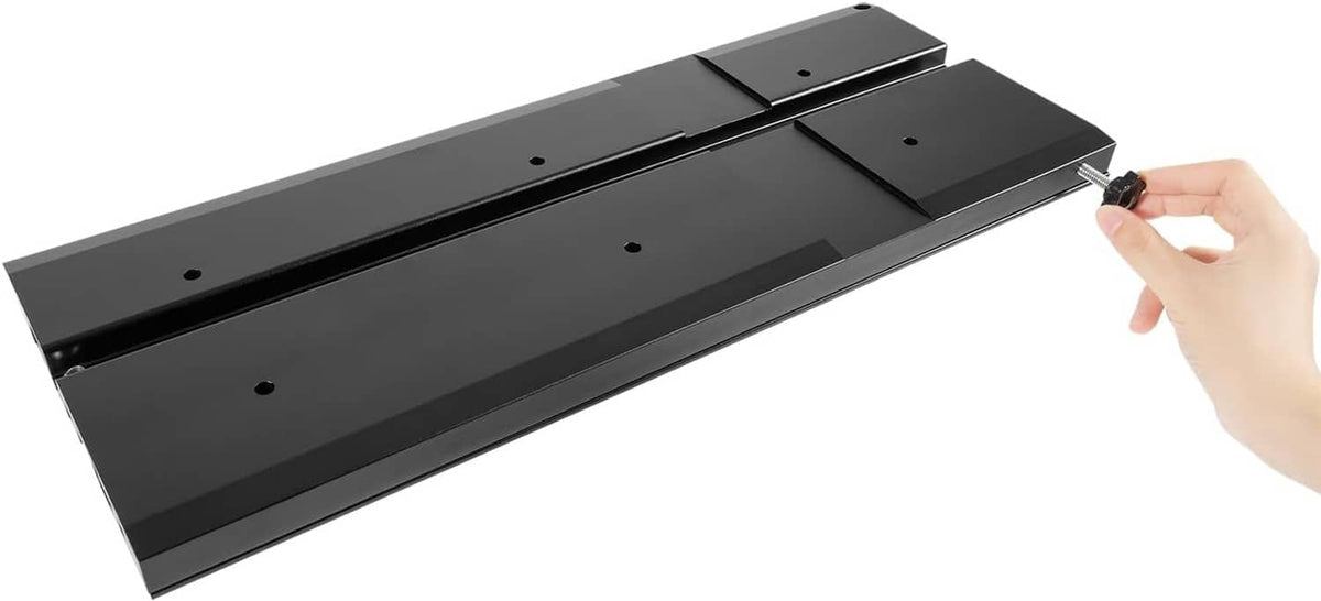 Black quick release bracket held by hand, showing mounting plate and slots
