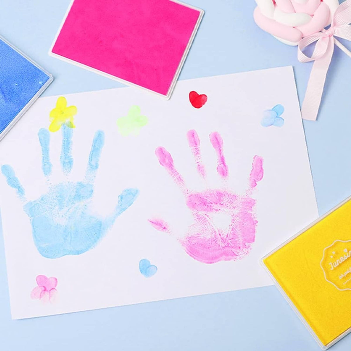Fingerprint ink pads producing colorful handprints on craft paper