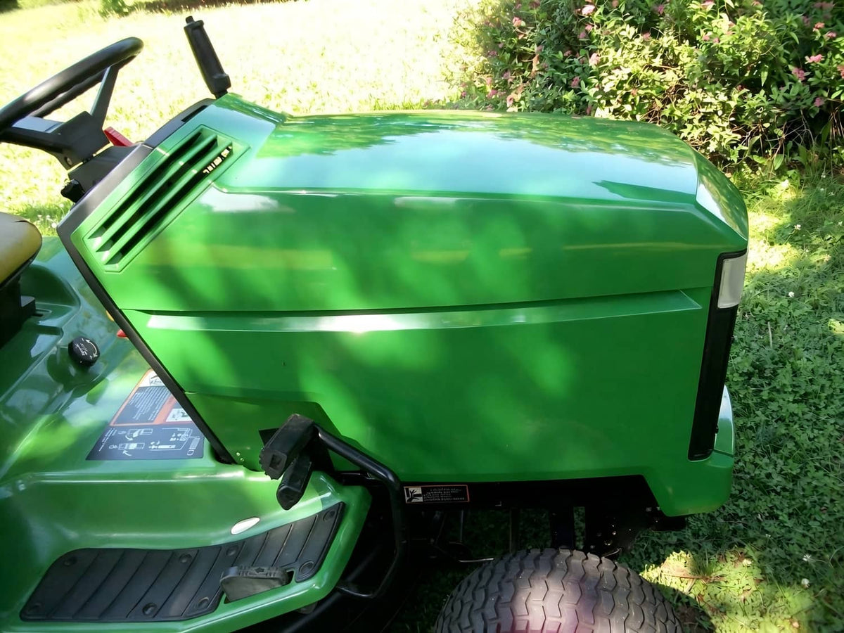 Green John Deere hood assembly installed on riding mower, shown from front-right.