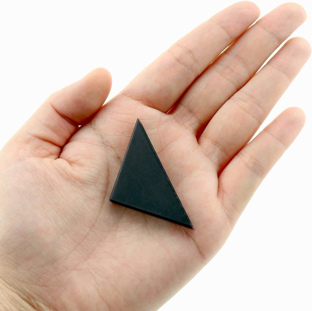 Black triangular corner protector held in hand, small edge cap