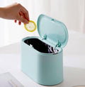 Light blue mini trash can with open lid and inner hooks, small waste inside