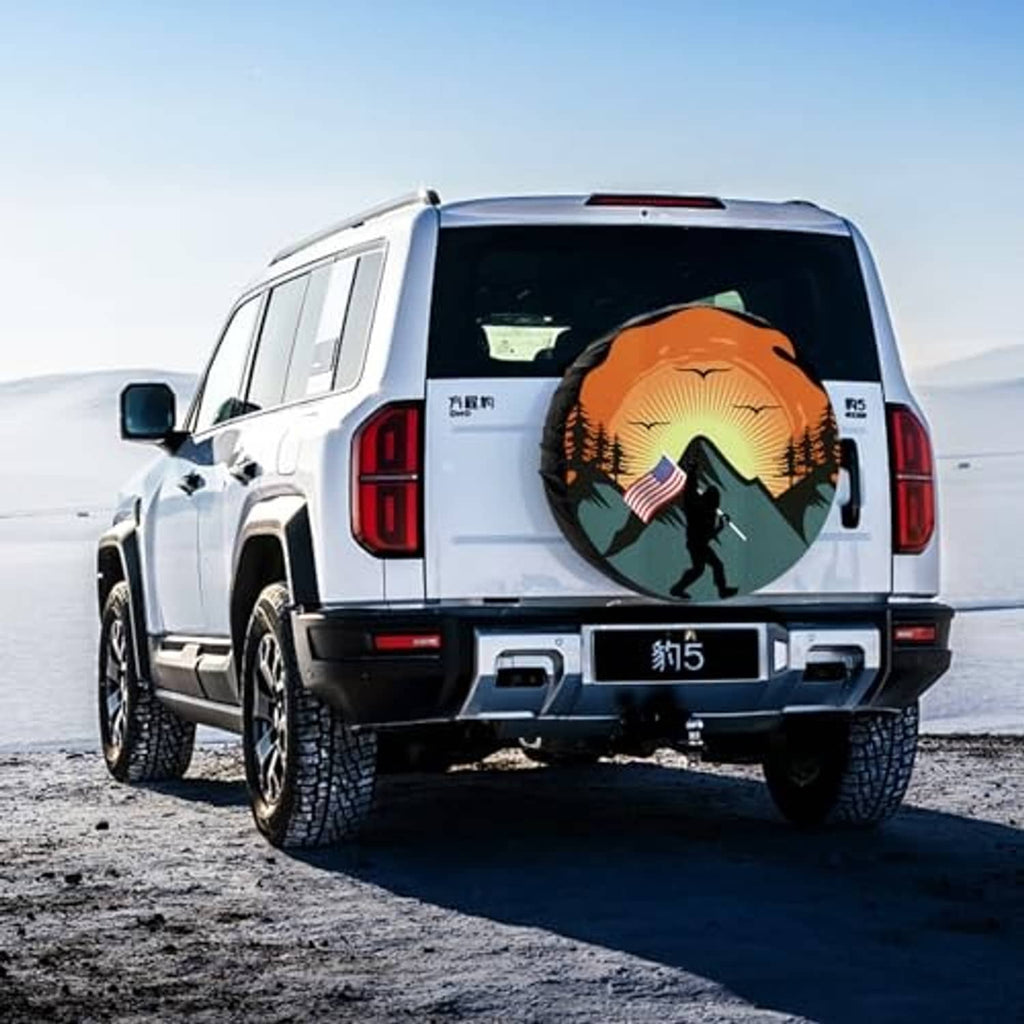 Spare tire cover on RV rear door, orange sunset mountains and hiker with US flag