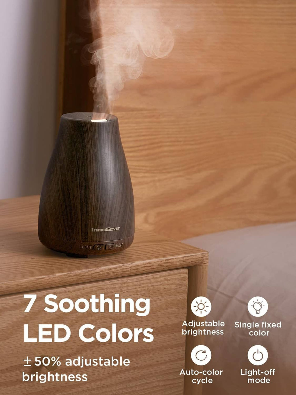 Brown ultrasonic essential oil diffuser on wooden surface with mist and glowing LED colors
