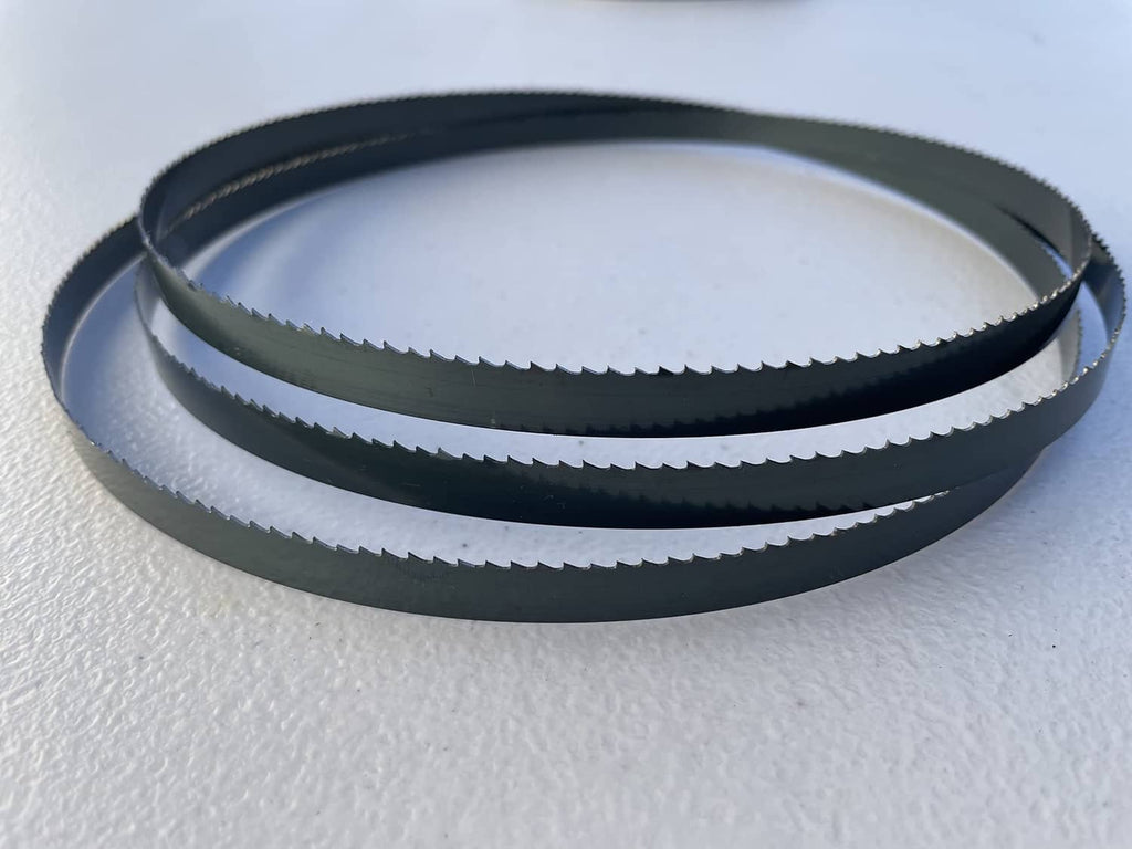 Dark blue wood bandsaw blades, stacked coiled loops with serrated teeth