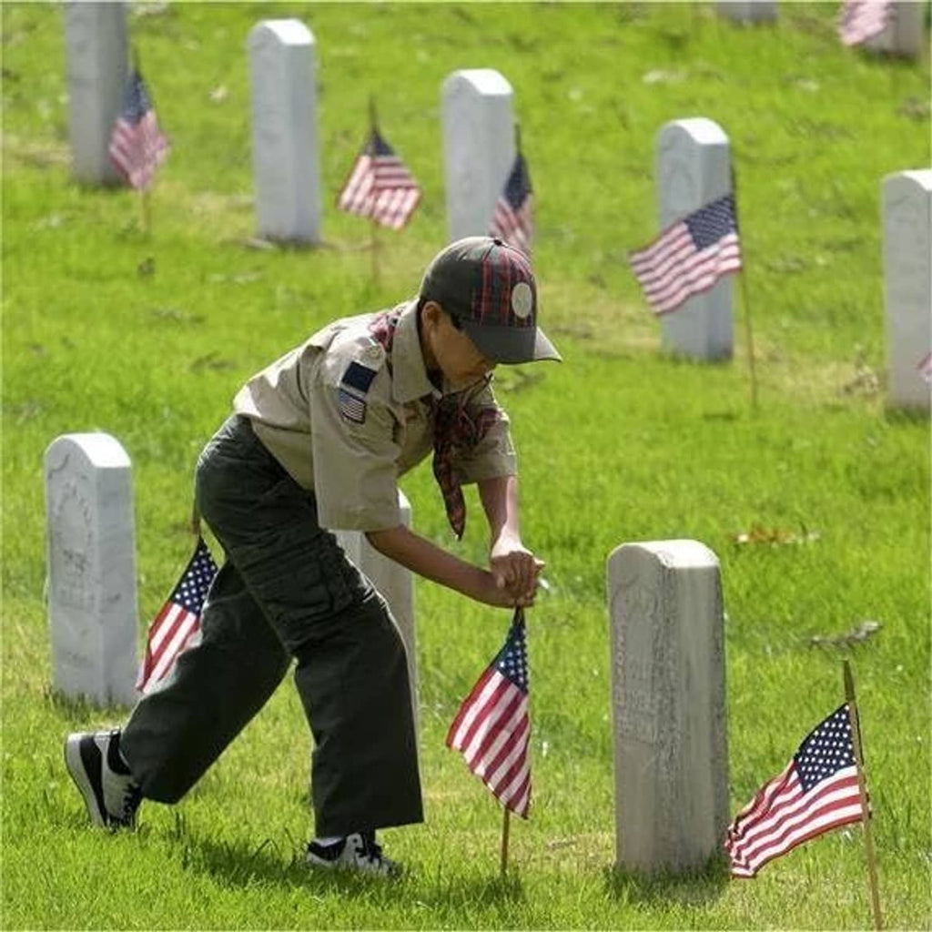 American flag lawn flags on wooden stakes planted in grass, red stripes and blue stars