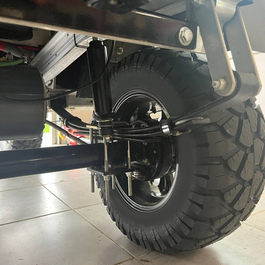 Underbody view of black rear leaf springs mounted near the rear tire