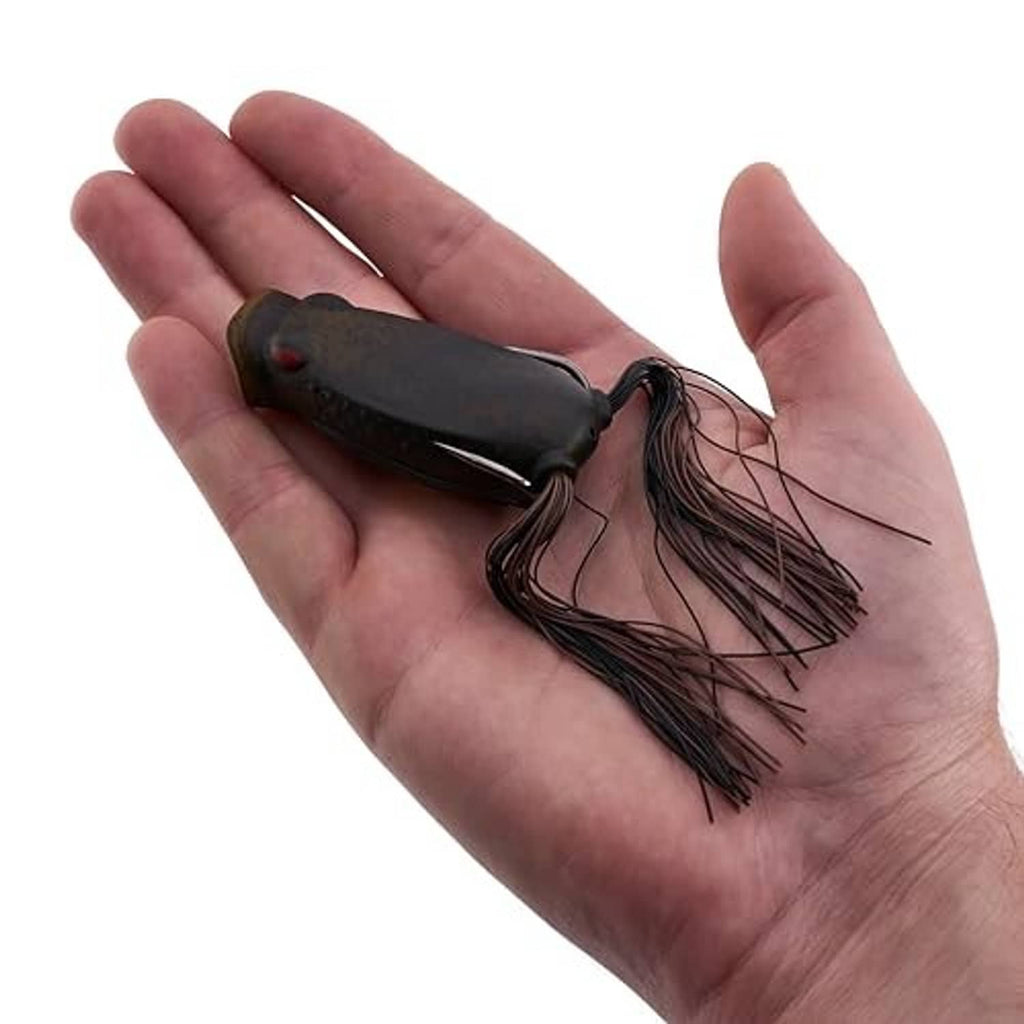 Frog popping fishing lure resting in an open hand, showing skirt and double hook