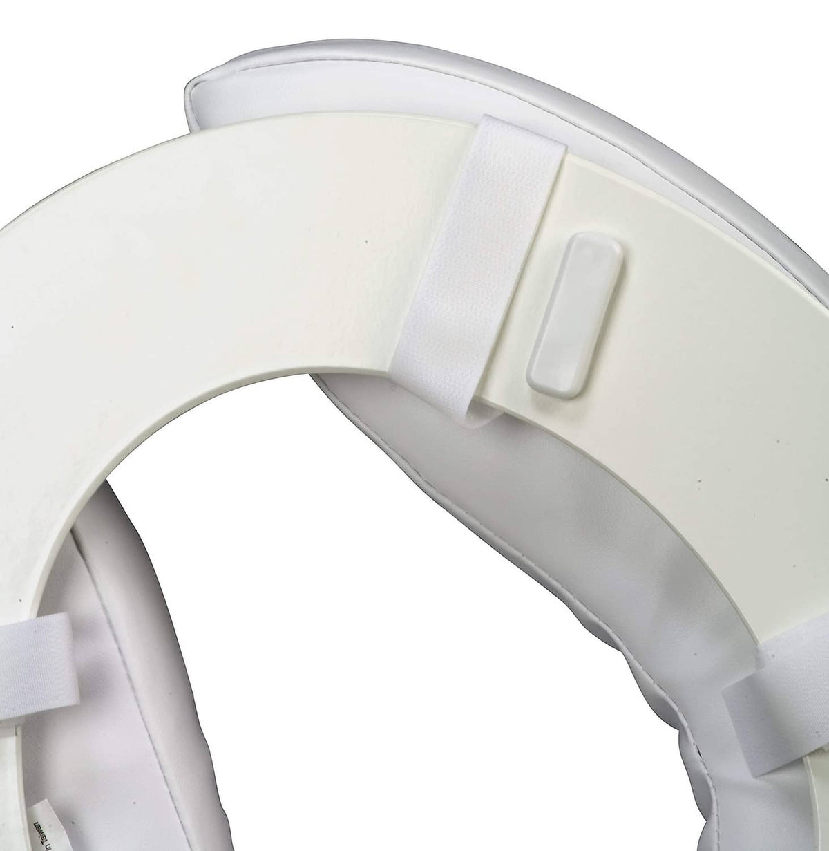 Close-up of toilet seat cushion straps securing around lid, white vinyl