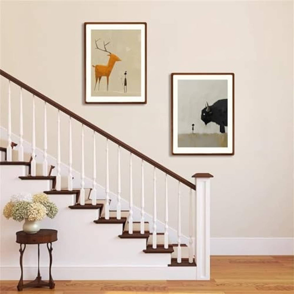 Walnut wood picture frames with white borders on a staircase wall, two frames shown