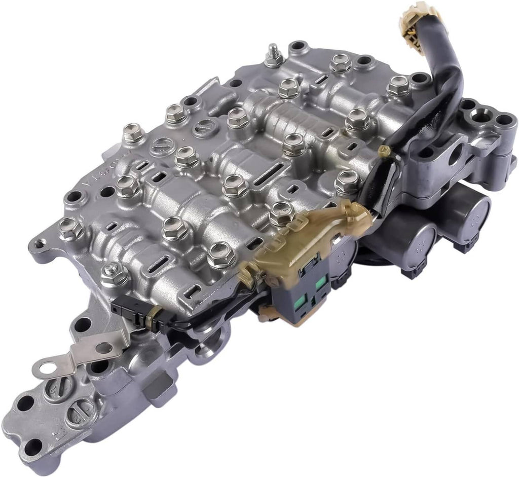 Automatic transmission valve body with attached solenoids and electrical connectors, silver-gray metal.