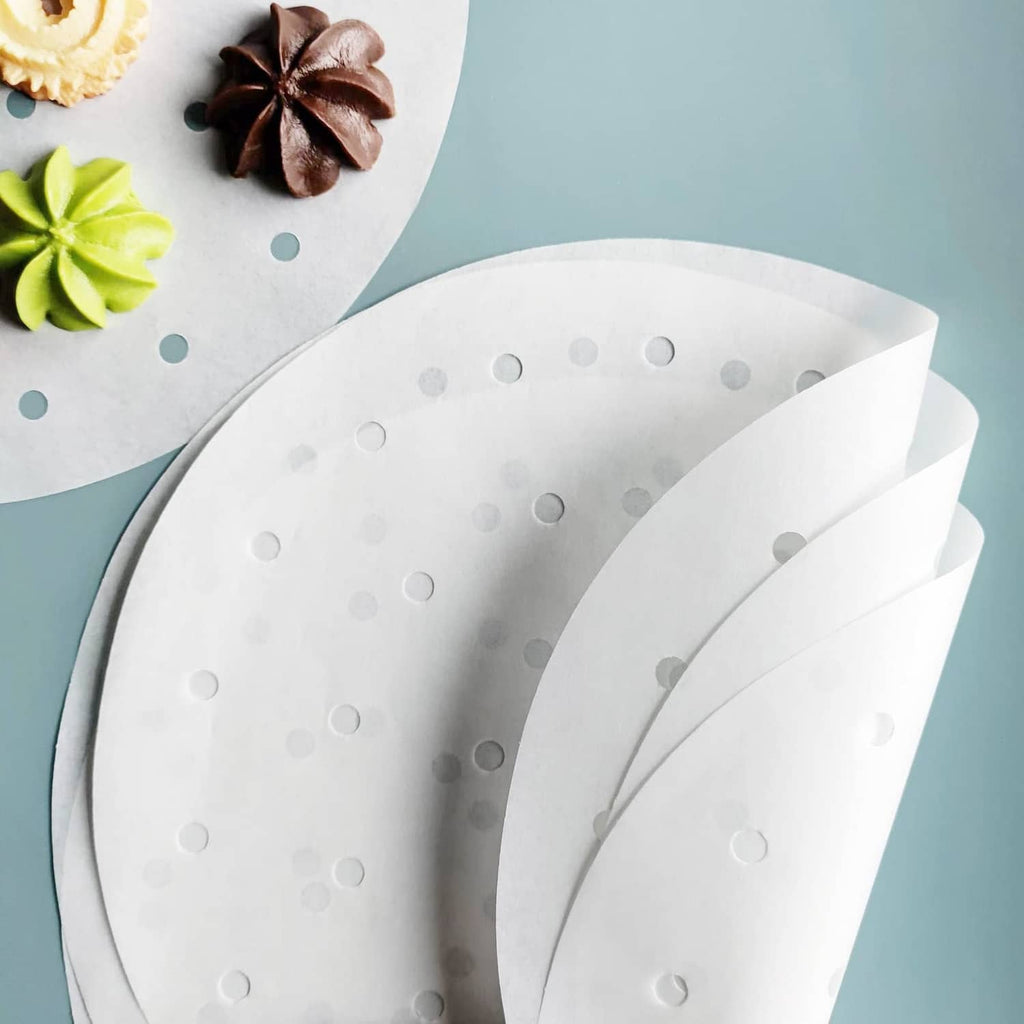 Overlapping round white air fryer parchment liners with evenly spaced holes