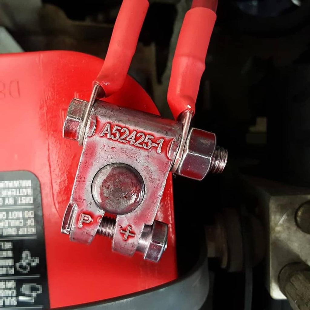 Close-up of a top-post battery terminal end with N and P studs on red battery