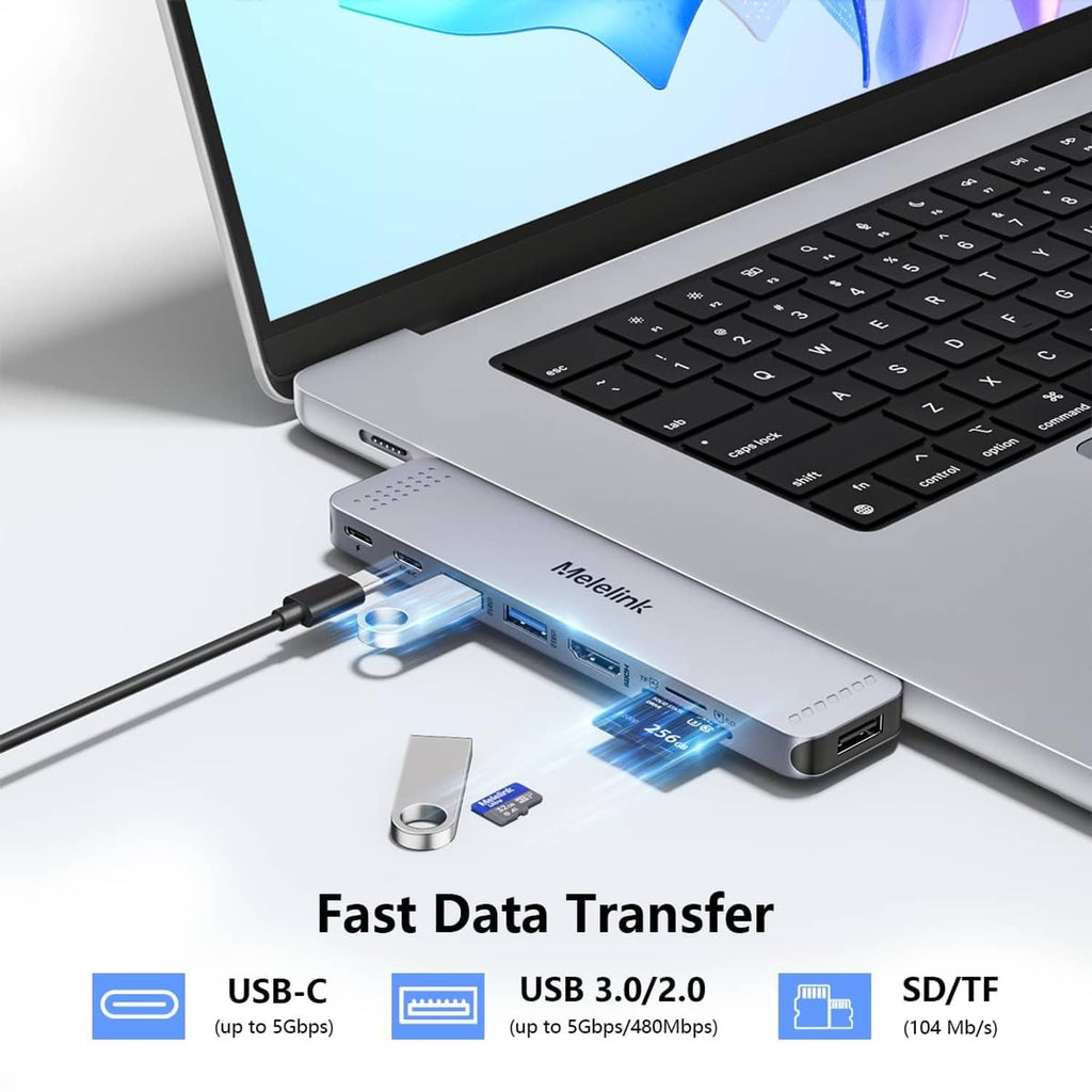 Gray USB-C hub connected to a laptop with illuminated data-transfer ports