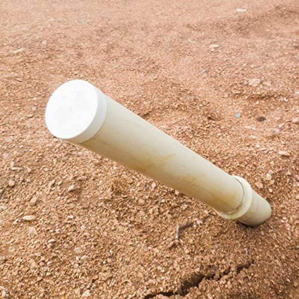 PVC pipe end cap fitting attached to a white pipe on the ground