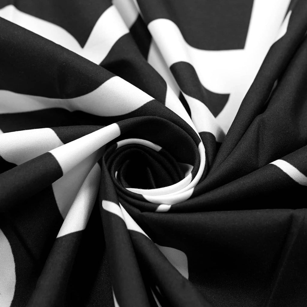 Black and white fabric close-up with bold graphic print and swirling lettering