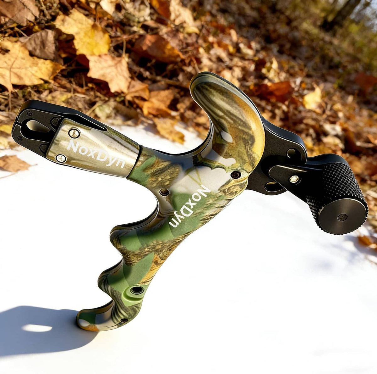 Archery bow thumb release with black trigger and camouflage handle on snow