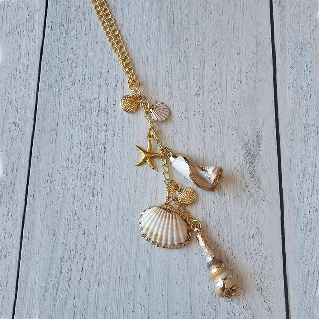 Close-up gold sea shell charm with starfish, conch shell, and crystal bead pendants