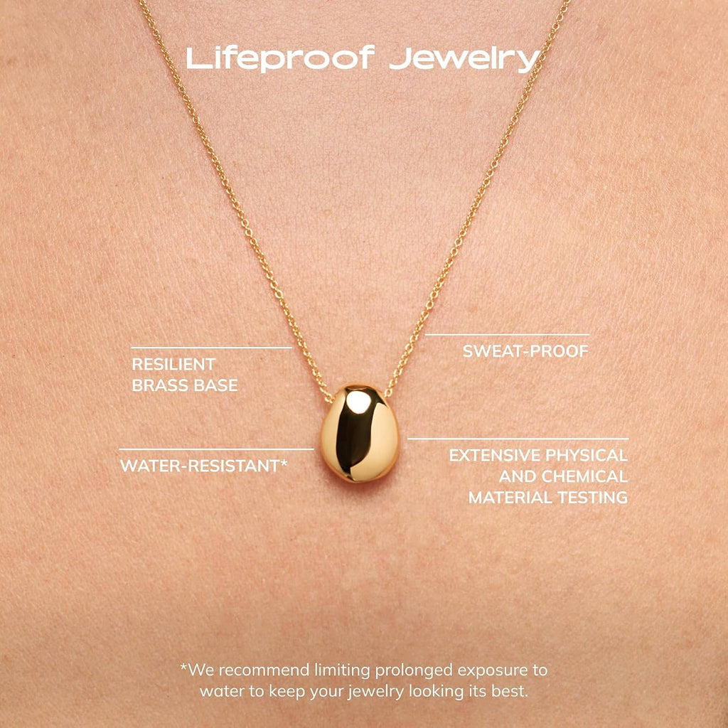 Gold-plated pebble pendant necklace close-up, oval pendant centered on thin chain