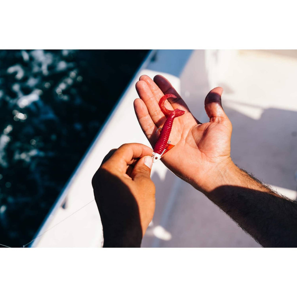 Red ribbed soft plastic worm lure on a fishing hook
