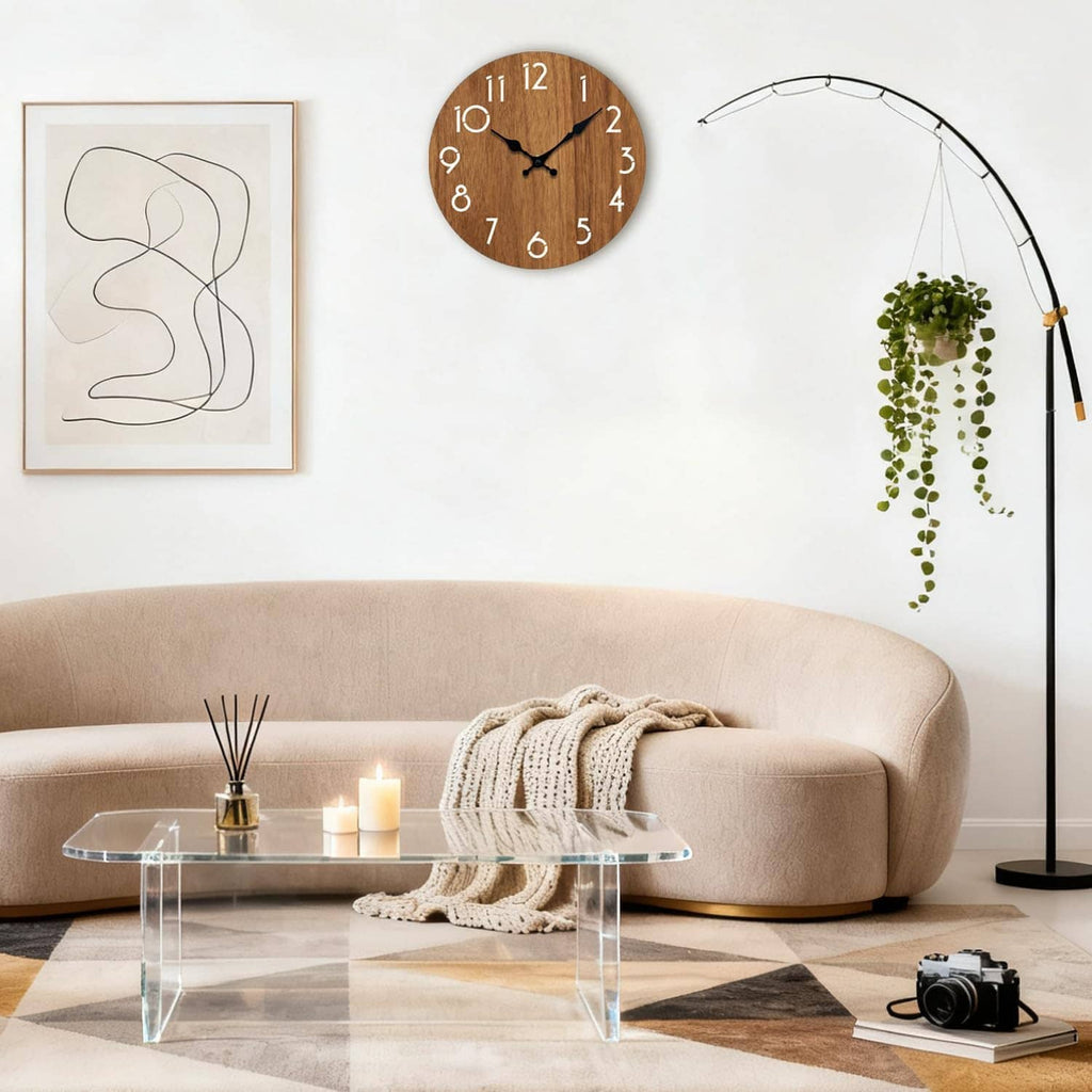 Round wooden wall clock with white hour markers and black clock hands above a sofa