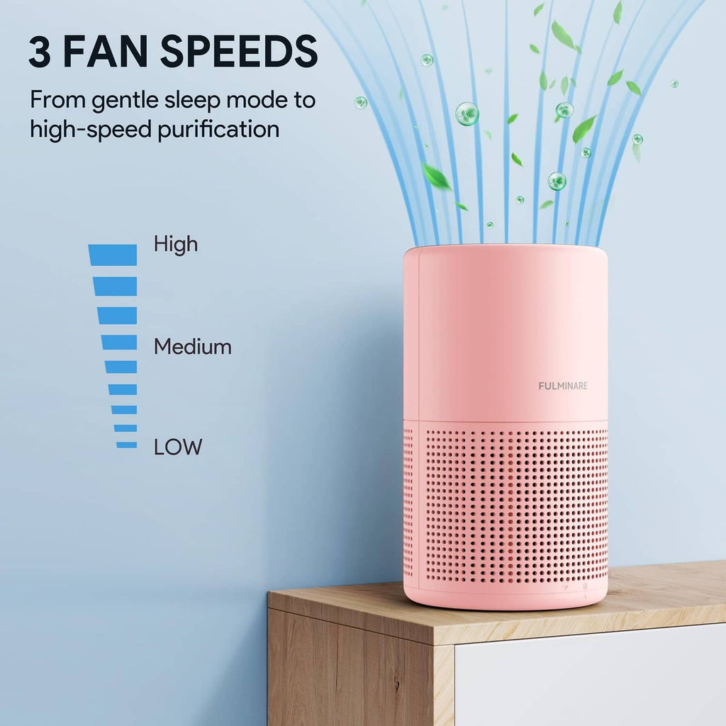 Pink air purifier with perforated intake grille on a tabletop