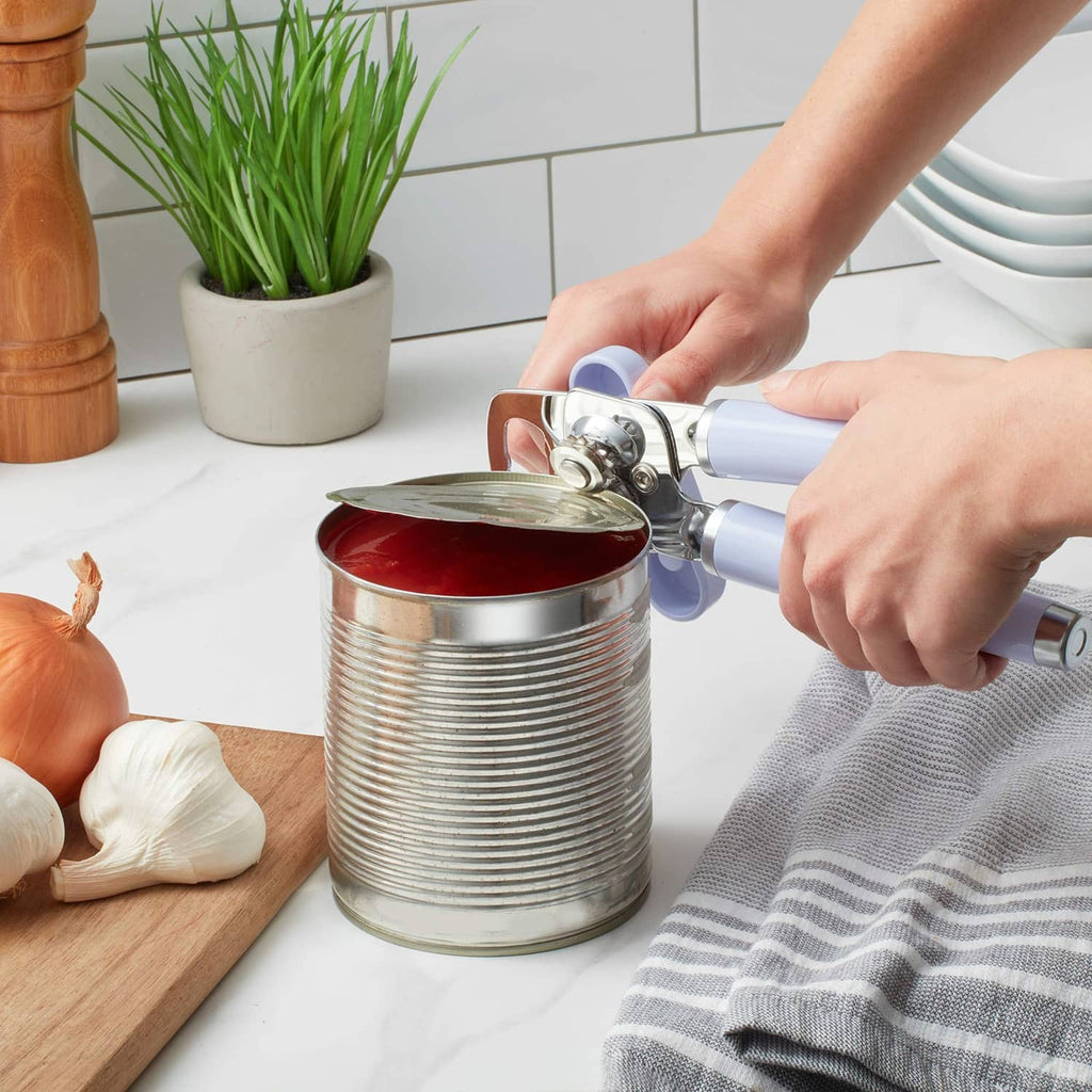 Lavender can opener in use, cutting the lid from a red canned food item.