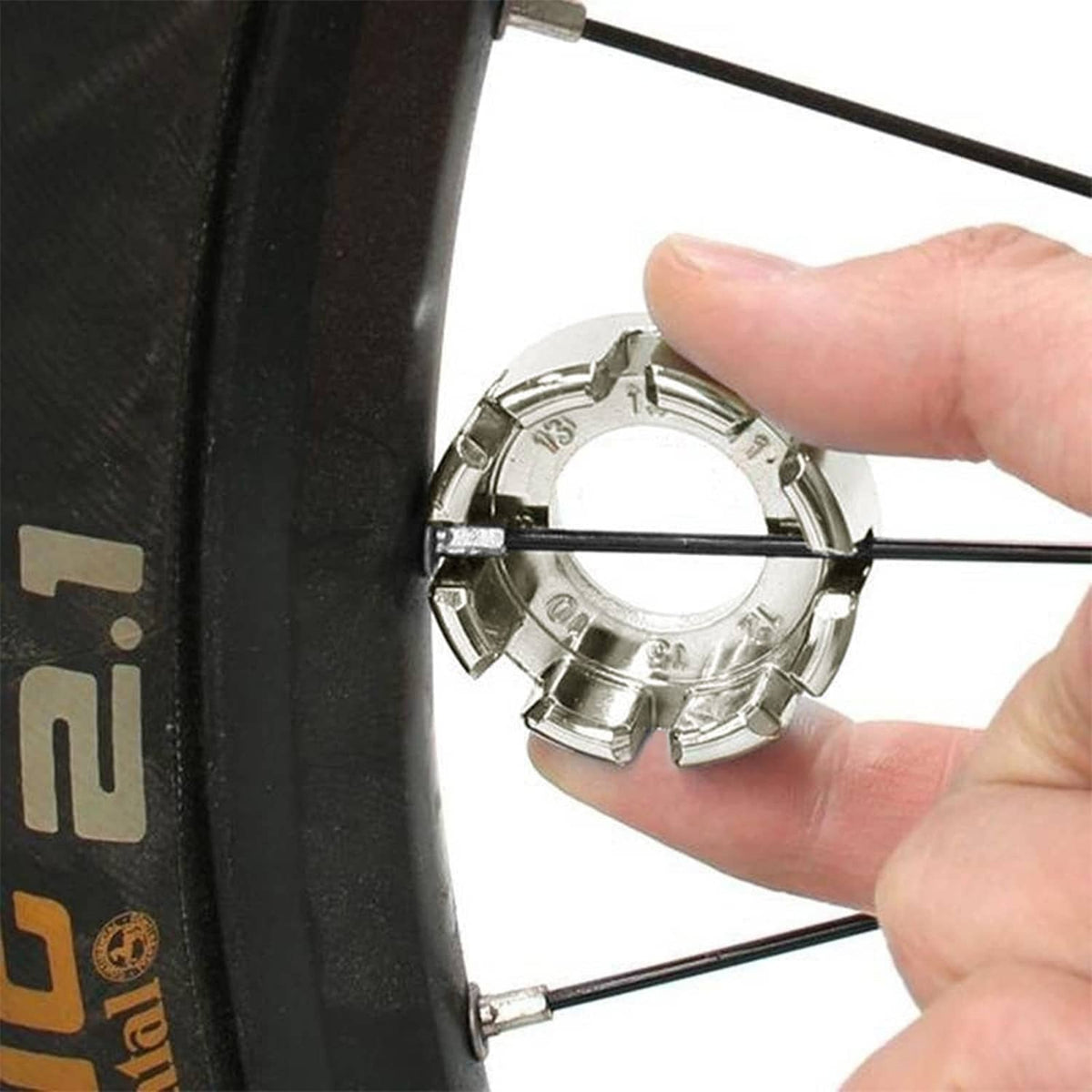 Bike spoke wrench tool with metal prongs fitting a bicycle rim spoke nipple
