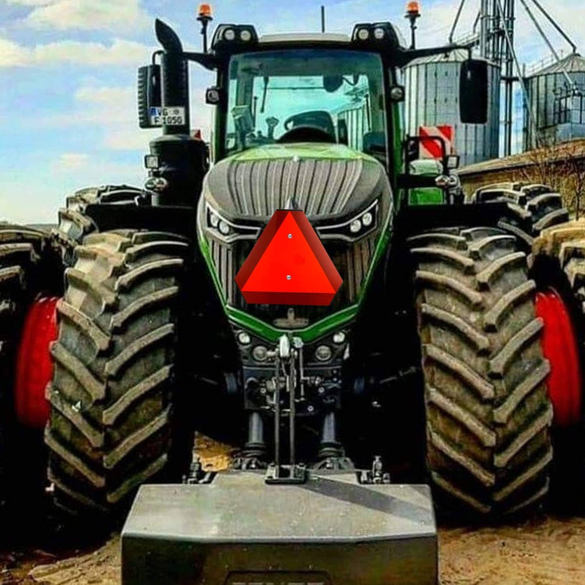 Slow moving vehicle triangle sign centered on a farm tractor front