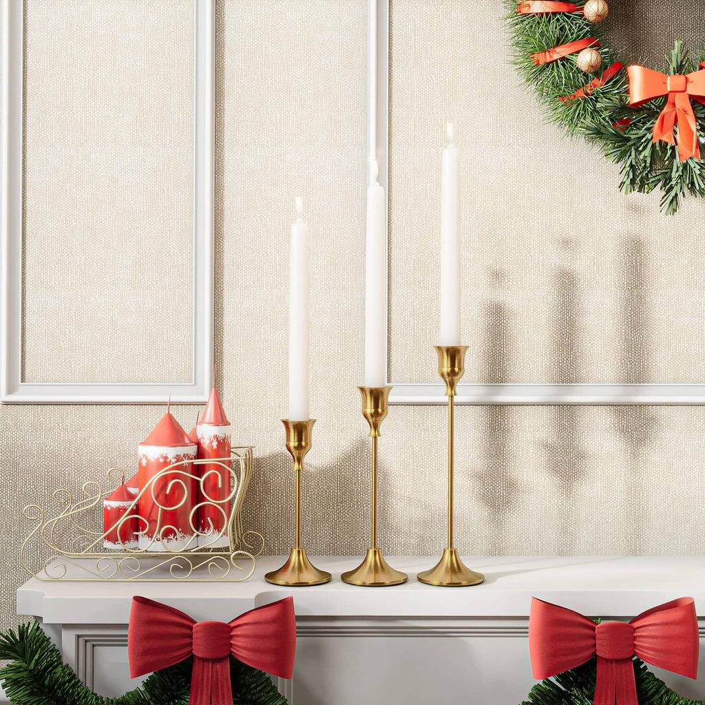 Brass gold candle holders set of six with lit candles on a mantel ledge