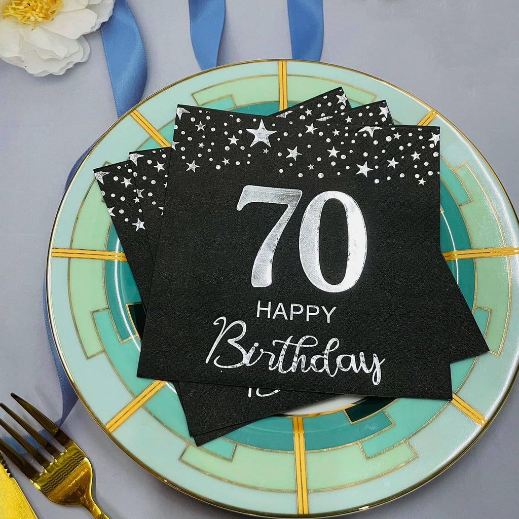 Black starry 70th birthday napkins stacked on a plate, silver “70 Happy Birthday”