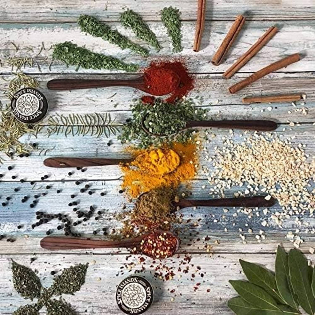 Ground spices on wooden board with herb sprigs and spice jar seals