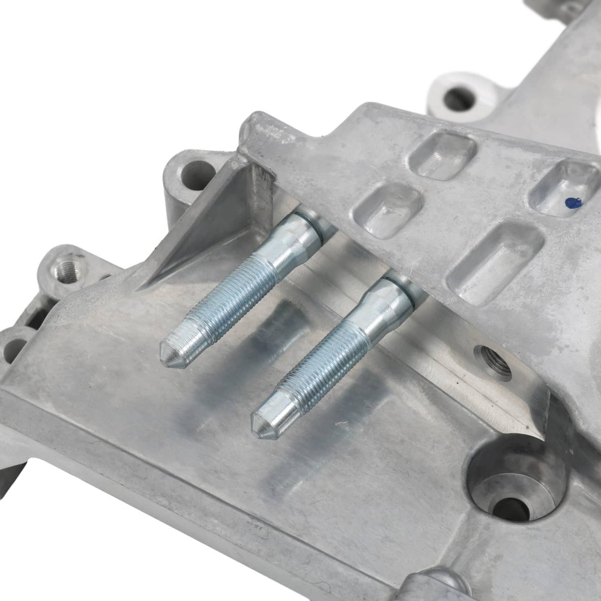 Timing cover oil pump housing close-up with two threaded bolts and silver metal channels