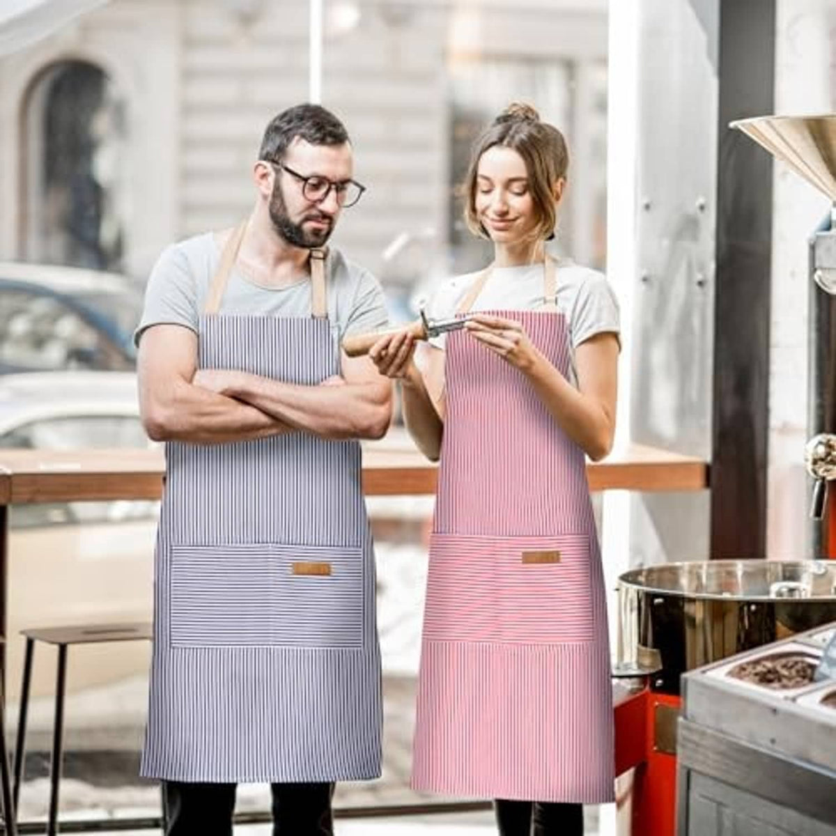 Two adjustable bib aprons in blue and pink pinstripes, each with front pocket
