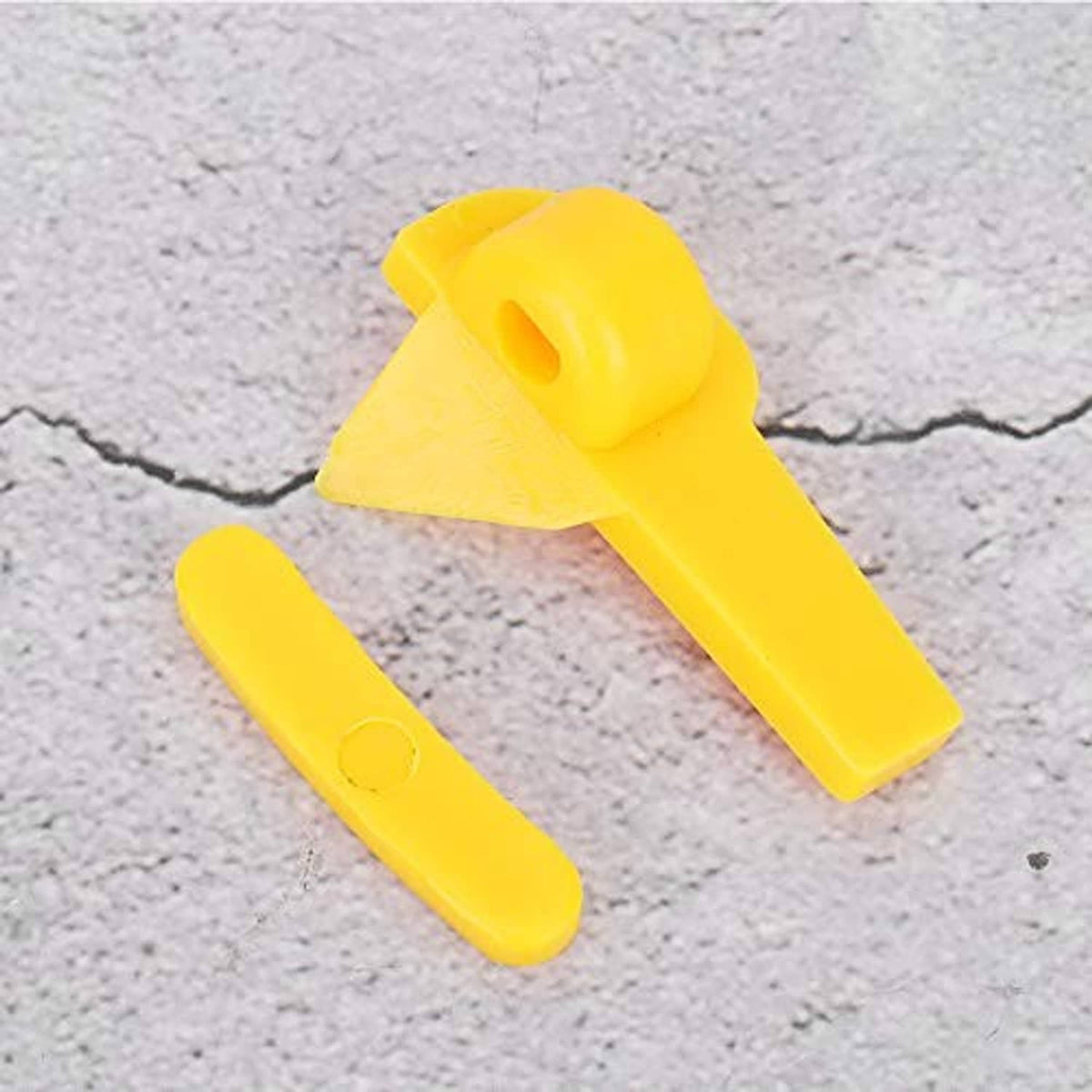 Two yellow plastic tire changer head protector inserts on concrete surface