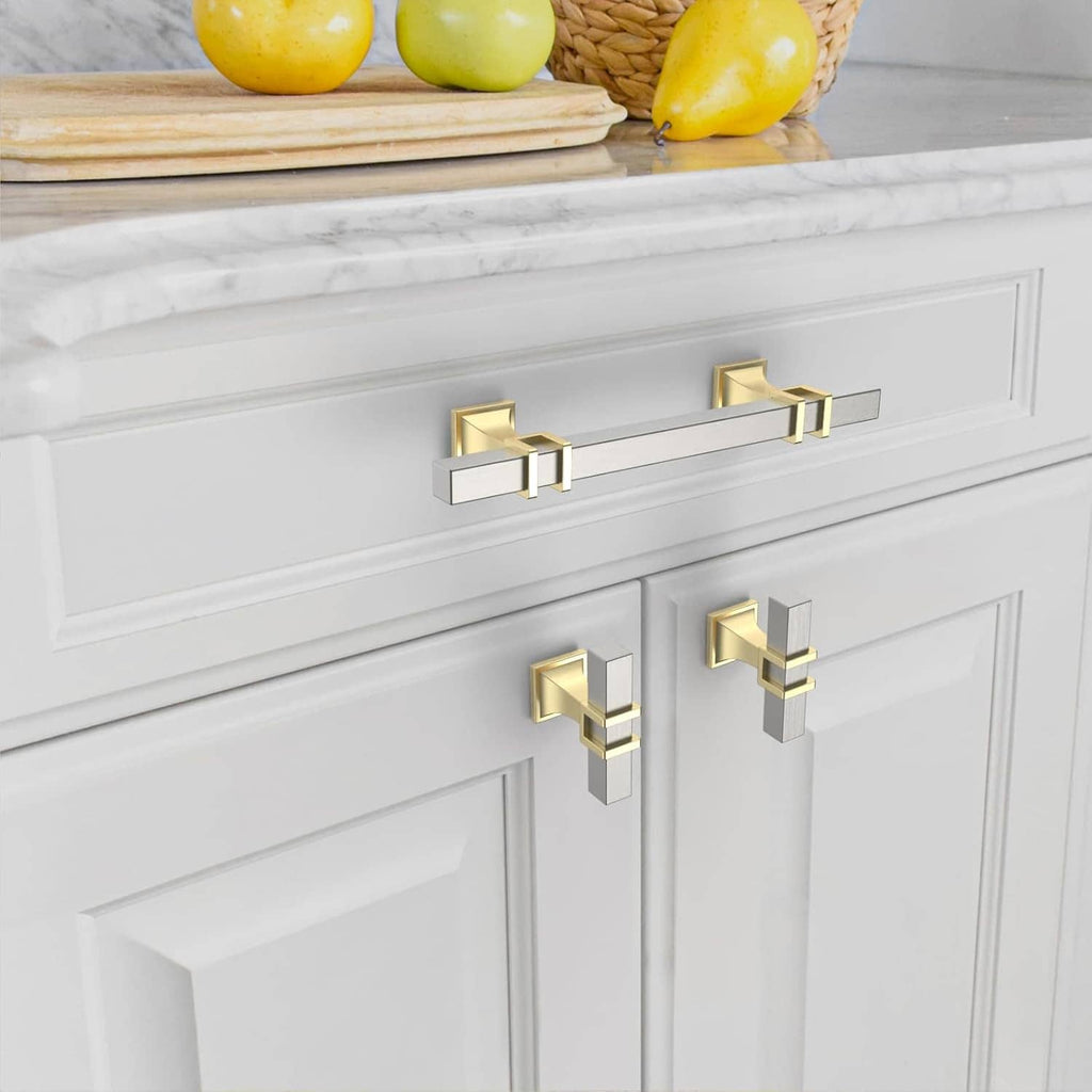 Gold and brushed satin nickel cabinet knobs mounted on white cabinet doors