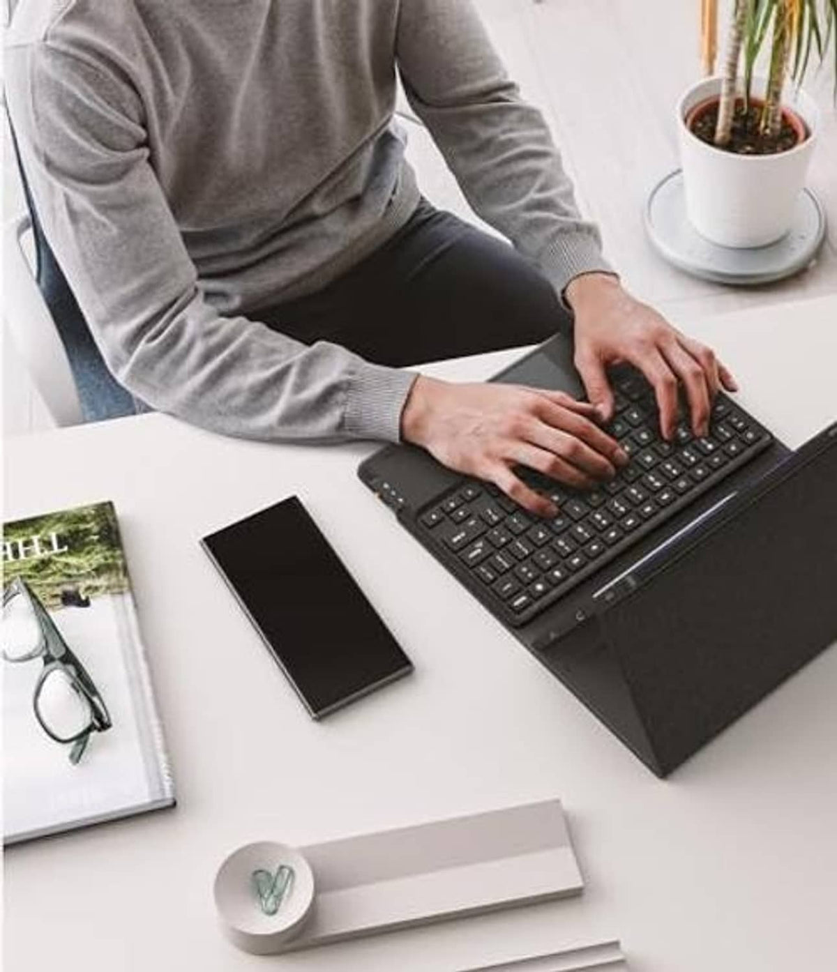 Black keyboard case with tablet and keyboard, hands typing on a desk
