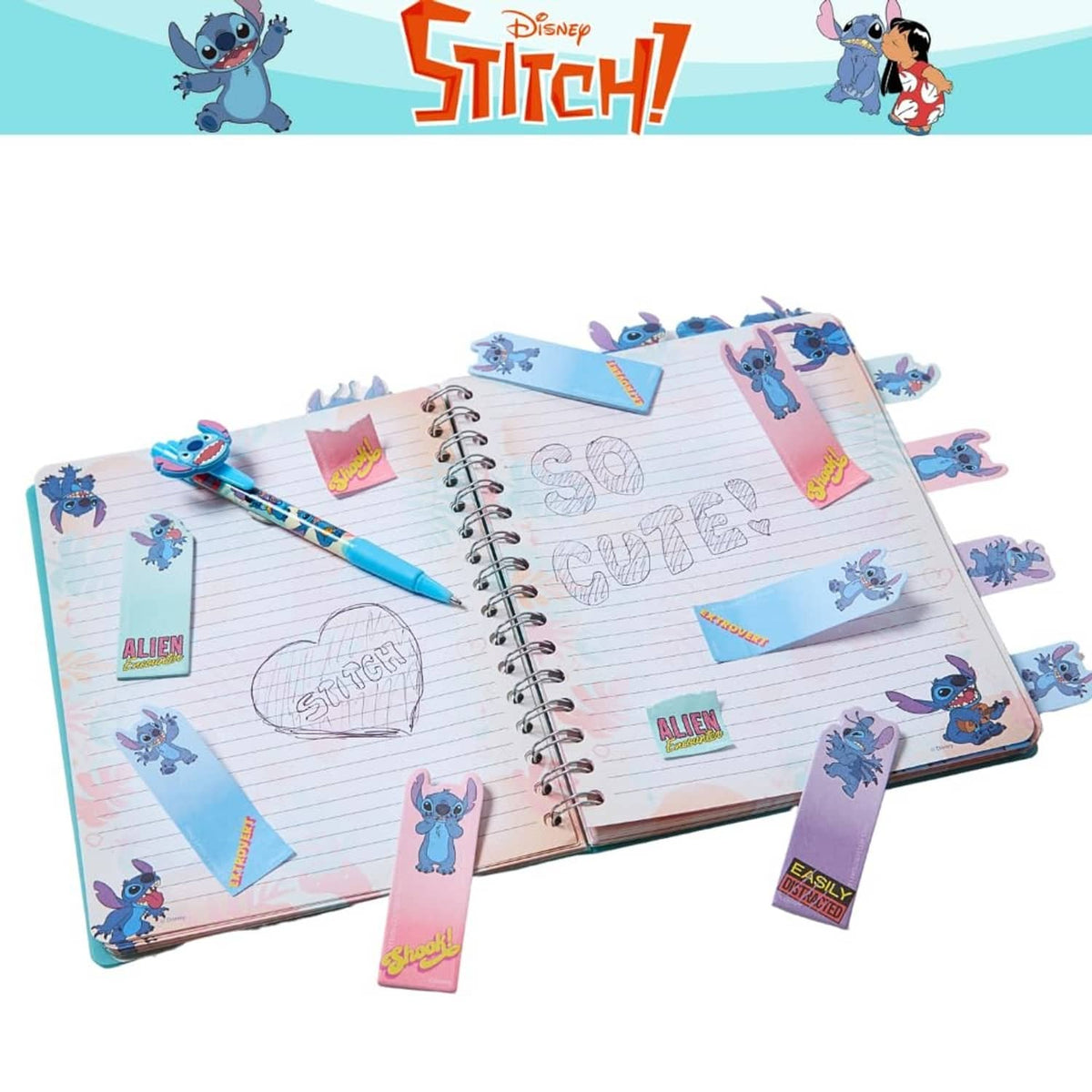 Open Stitch spiral journal with lined pages, sticky tab markers, and a blue pen.