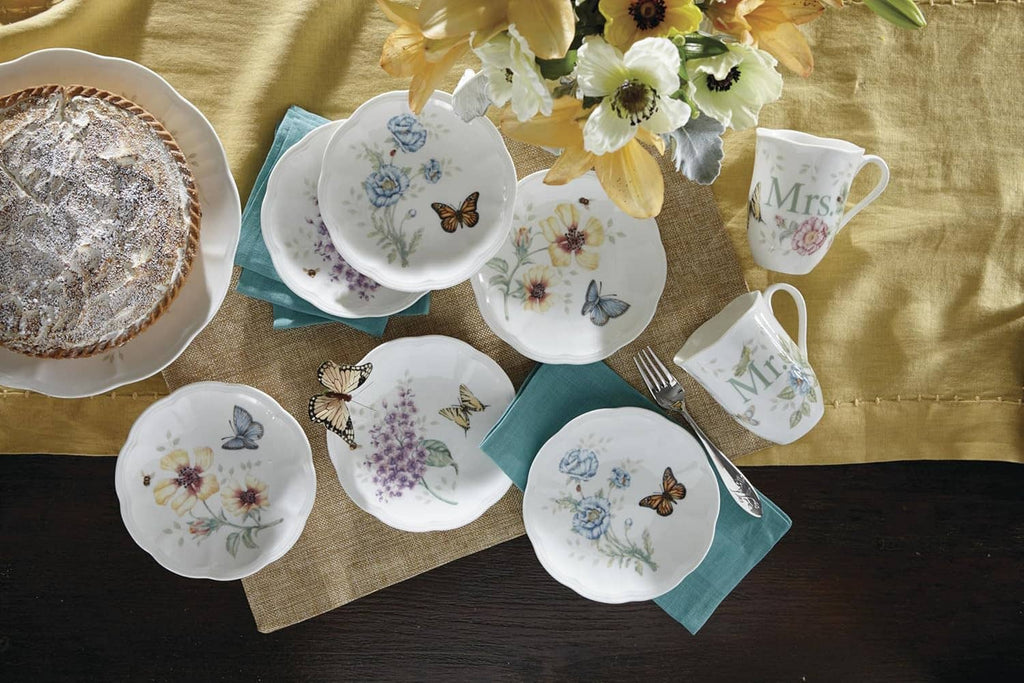 Assorted small round plates with butterfly and flower artwork on white porcelain