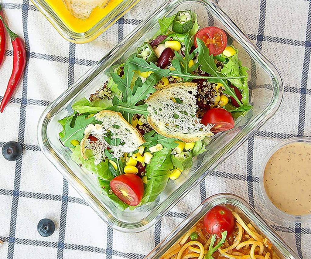 Clear glass meal prep dish filled with salad and tomatoes