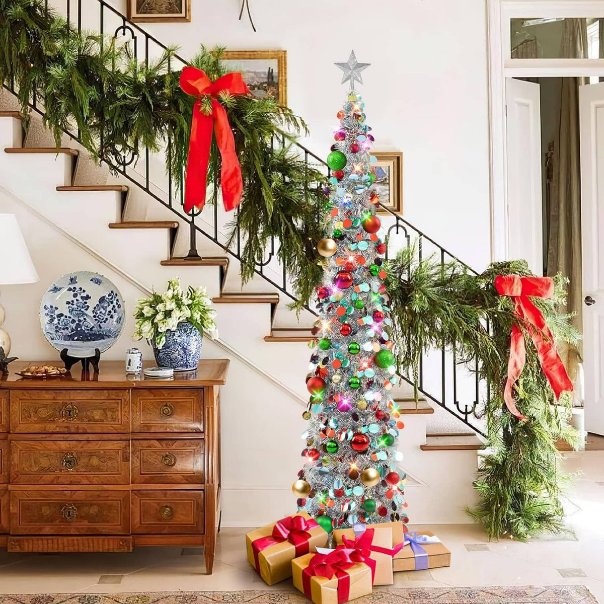 Silver tinsel Christmas tree with star topper, multicolor ornaments, and lit LED lights