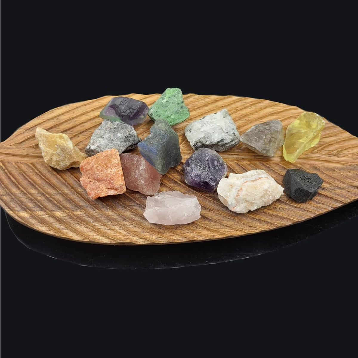 Rock and mineral collection of assorted rough stones on a wooden tray
