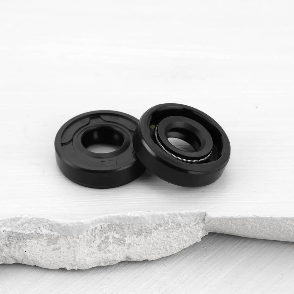 Pair of black radial shaft seals with central opening on white surface