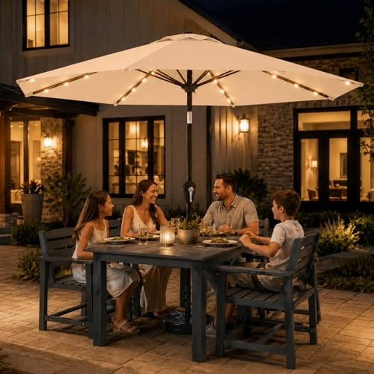Khaki patio market umbrella with warm solar LED lights above outdoor dining table.