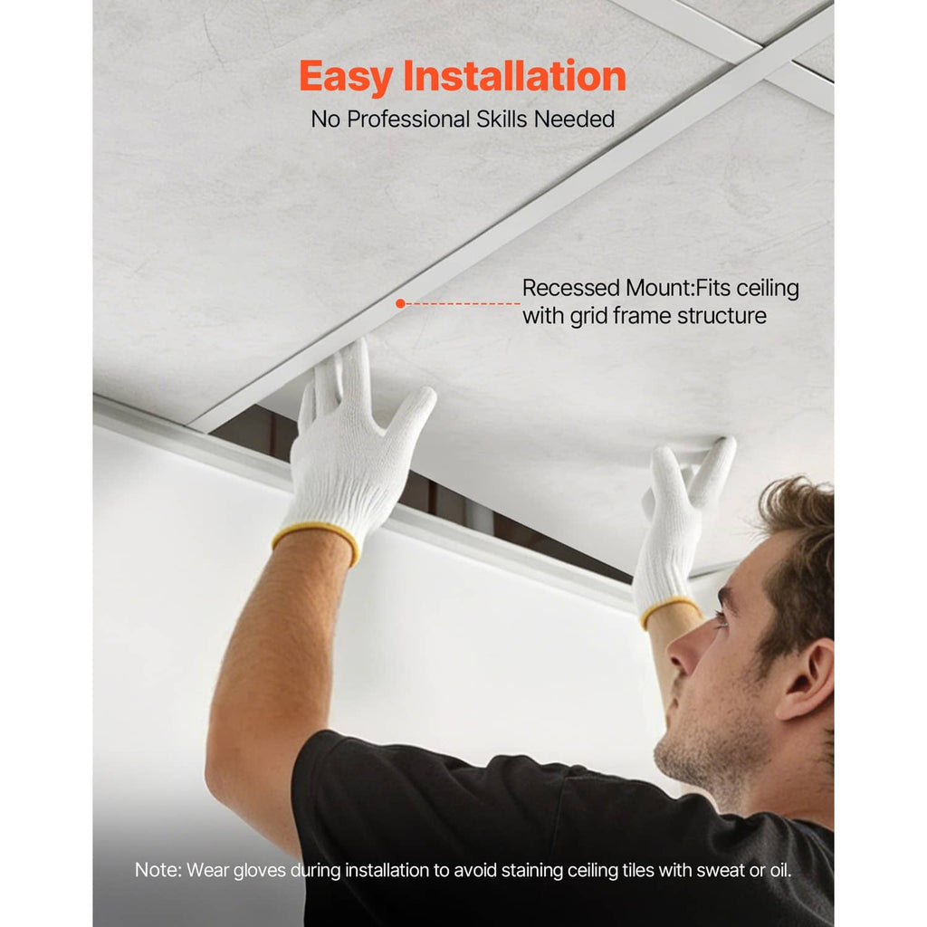 Person installing white marble-look PVC ceiling tiles into a recessed ceiling frame