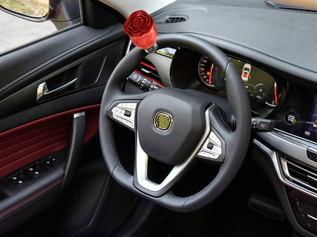 Red rose spinner knob mounted on car steering wheel center