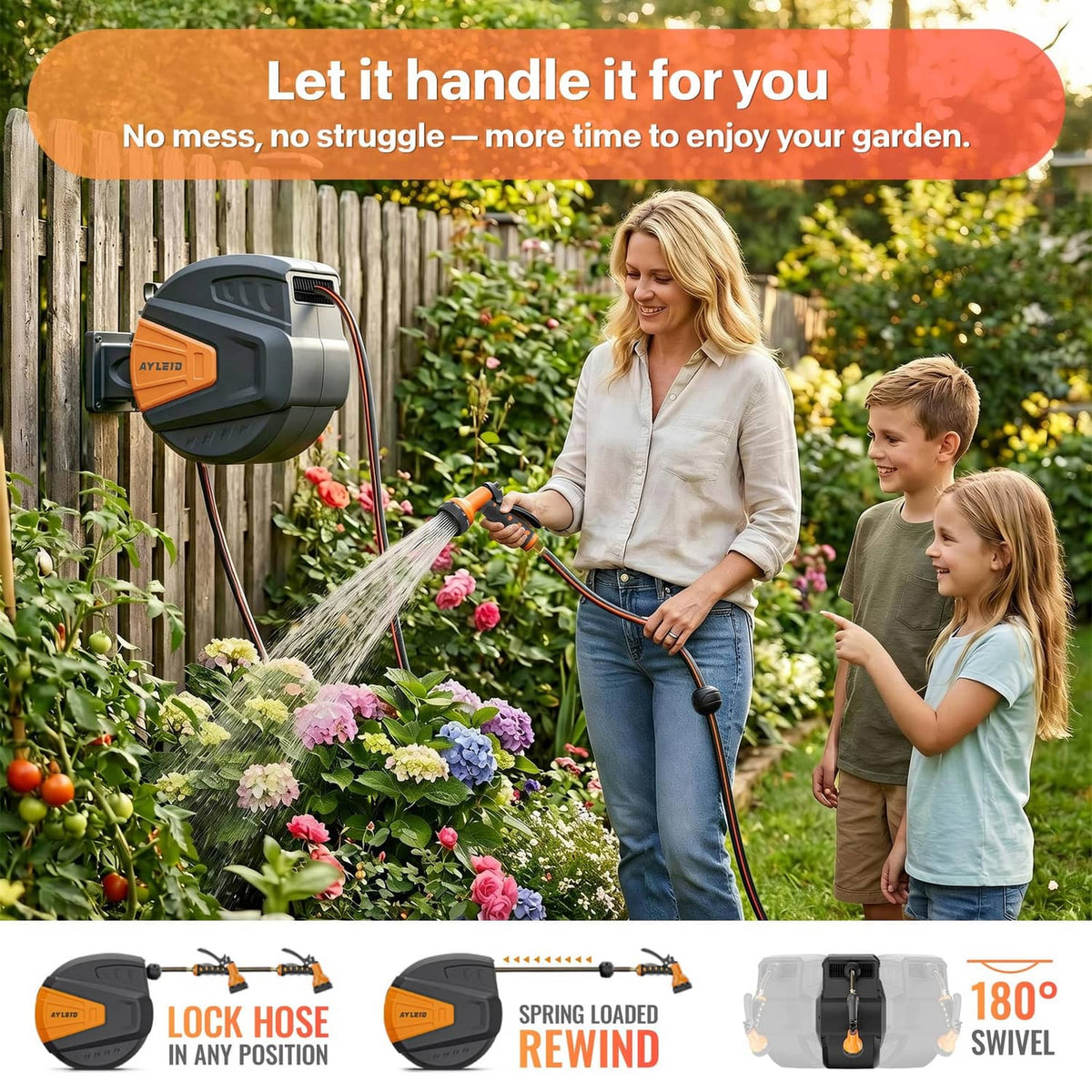 Retractable hose reel on a fence with the hose nozzle spraying toward flowers