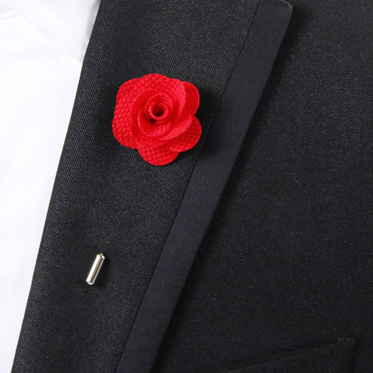 Red fabric rose lapel pin on dark suit lapel, close-up