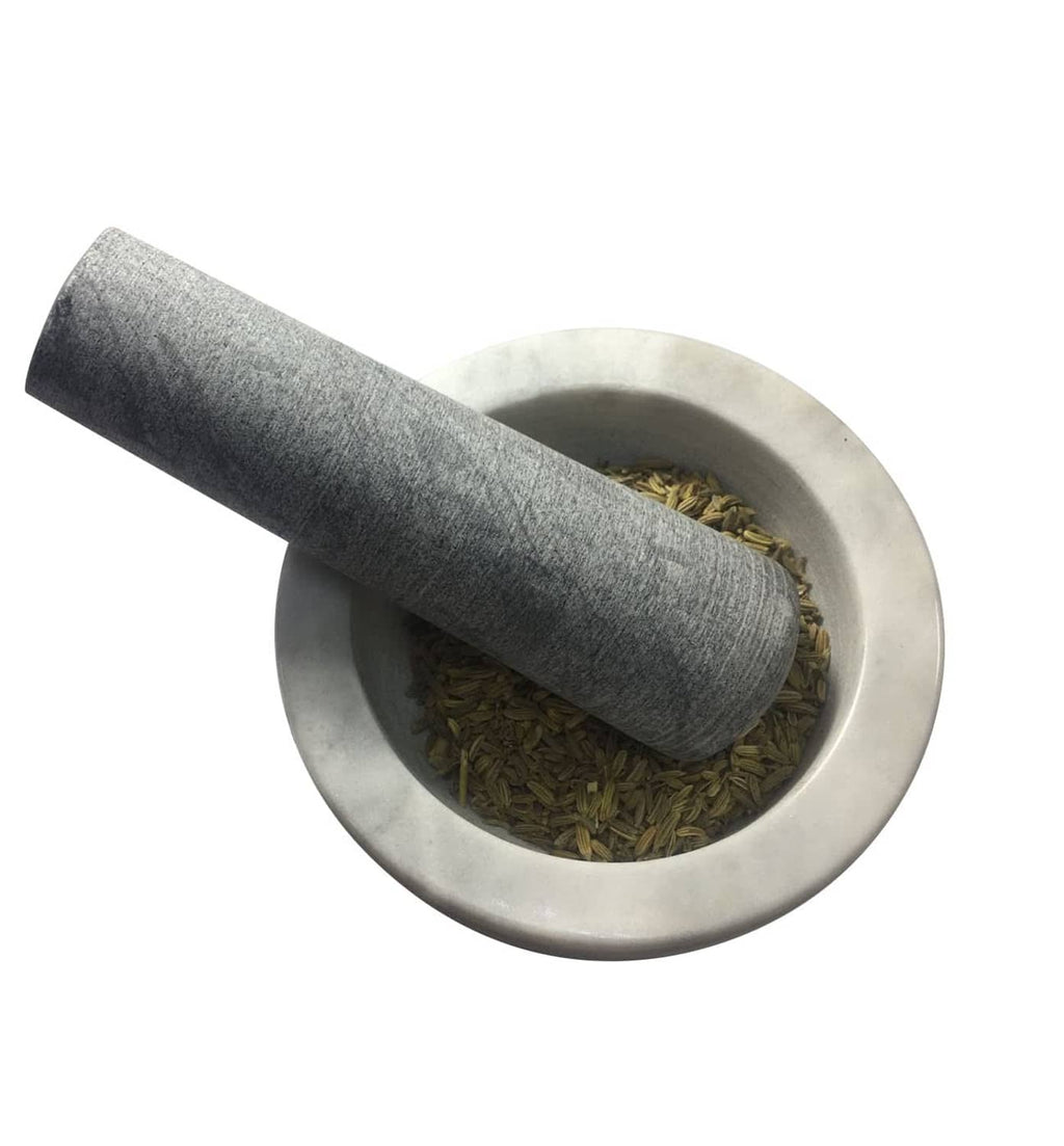 Gray pestle replacement shown over a bowl with dried herbs