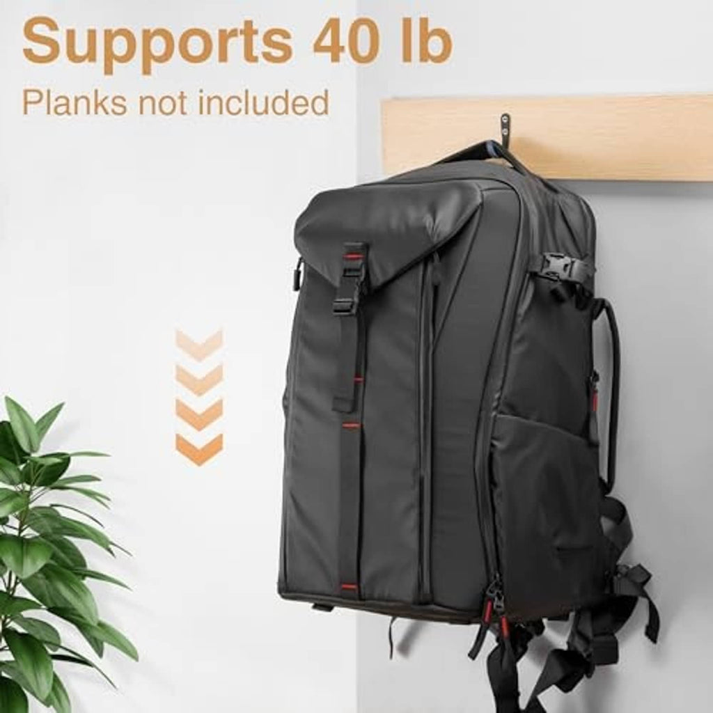 Black metal wall hook holding a backpack strap on a wall